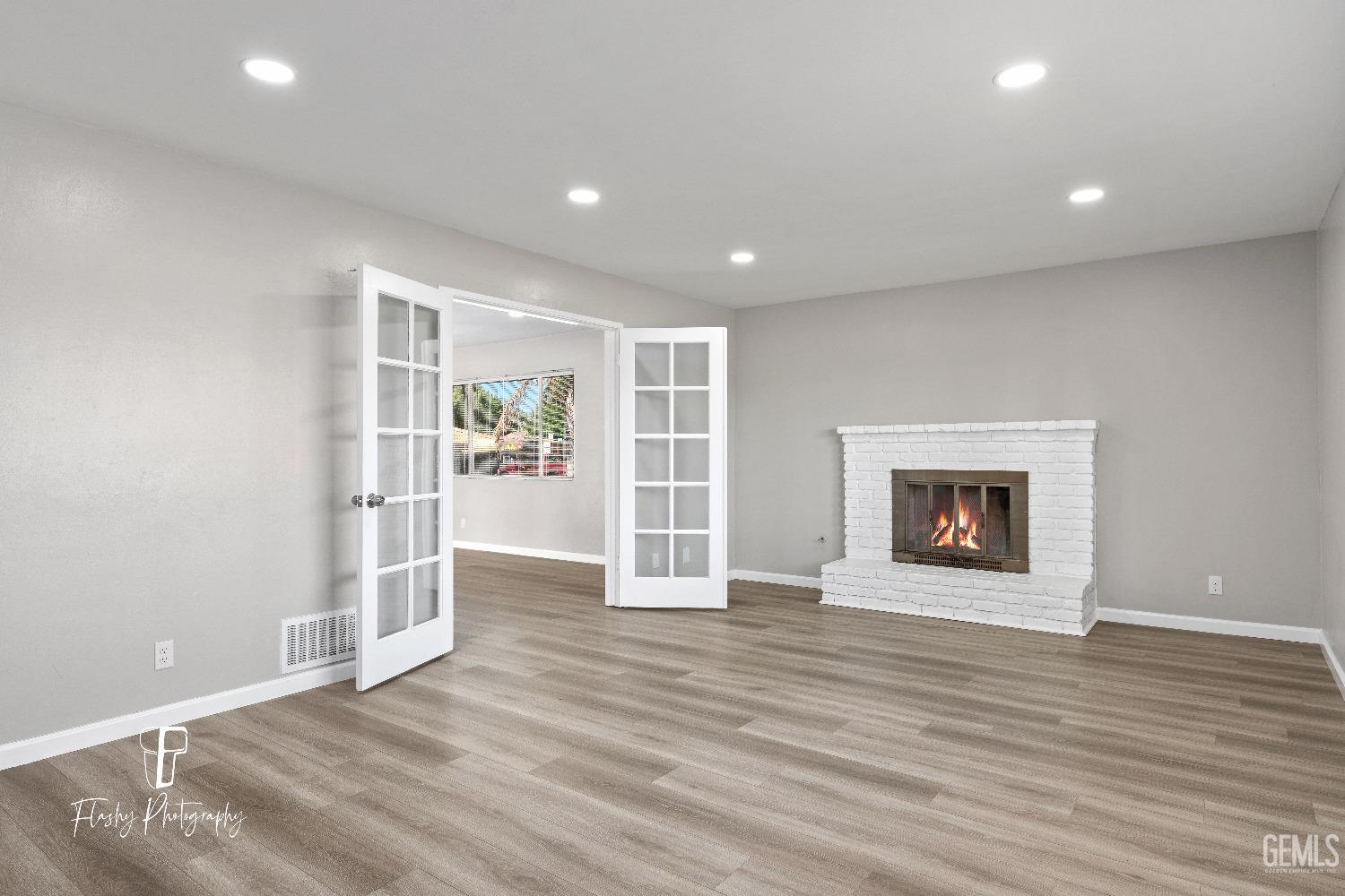 Undisclosed Address Bakersfield, CA 93308 - Photo 8 of 37 an empty room with wooden floor and a fireplace