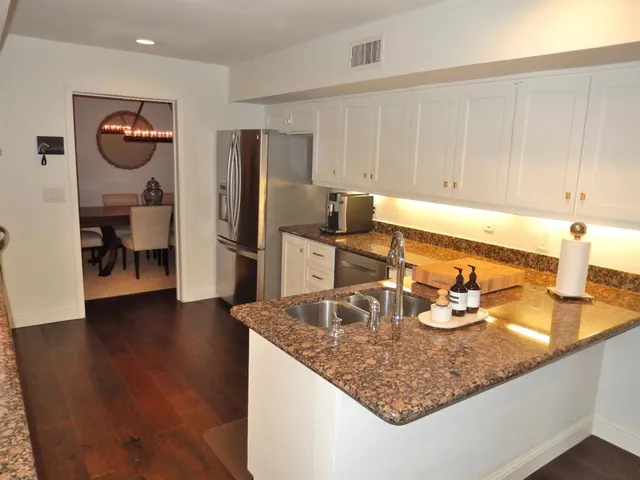 a kitchen with sink refrigerator and cabinets