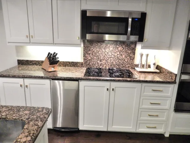 a kitchen with granite countertop a sink and a stove