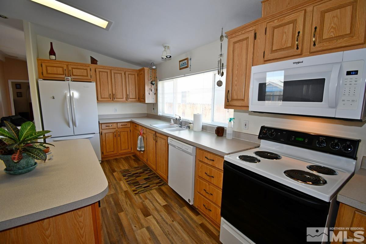 229 Mark Street Gardnerville, NV 89410 - Photo 5 of 24 a kitchen with stainless steel appliances a stove a microwave a sink and cabinets