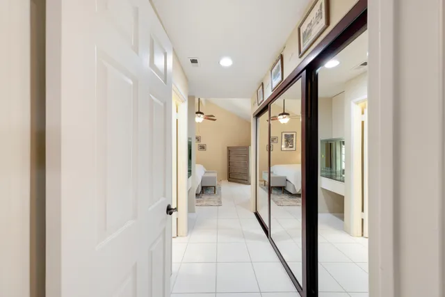 a view of a hallway with wooden floor and a bathroom