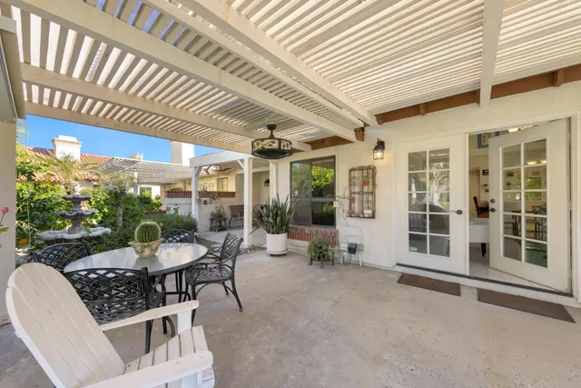 a view of a patio with a table and chairs and potted plants
