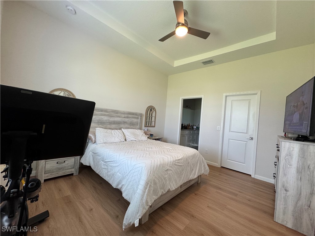 1818 Inwood Road LaBelle, FL 33935 - Photo 16 of 28 a bedroom with a bed and a flat tv screen on dresser