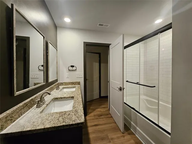 a bathroom with a granite countertop sink and a large mirror