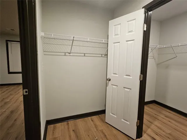 a view of walk in closet with wooden floor