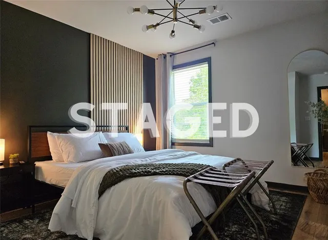 a bedroom with a bed and a chandelier