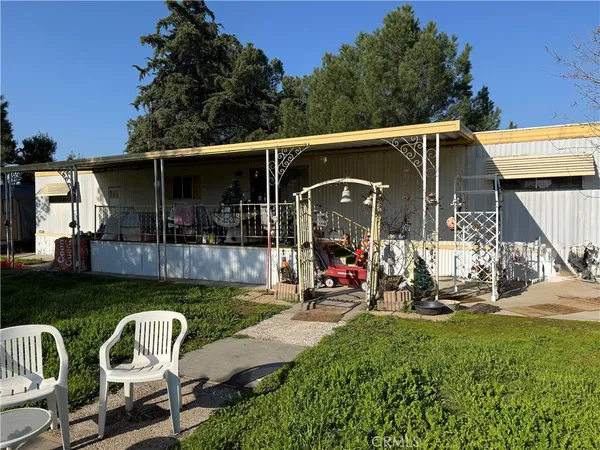 a view of a chair and table in backyard of the house