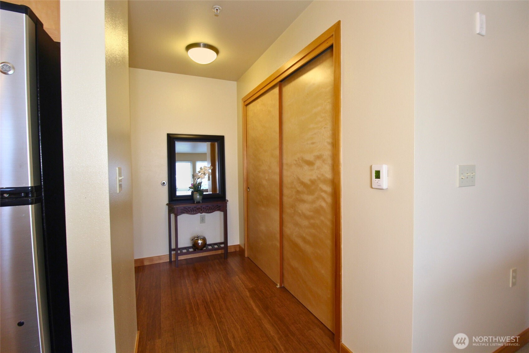 827 Hiawatha Place South, Unit 406 Seattle, WA 98144 - Photo 4 of 13 a view of a hallway with wooden floor and a bathroom