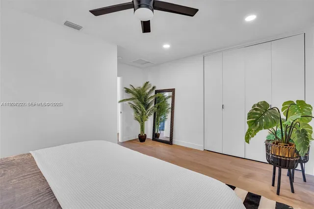 a bedroom with a bed and a potted plant