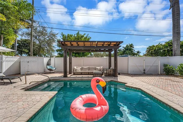 a view of a backyard with table and chairs potted plants and wooden fence