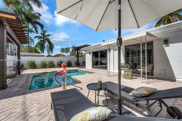 a view of a patio with table and chairs under an umbrella