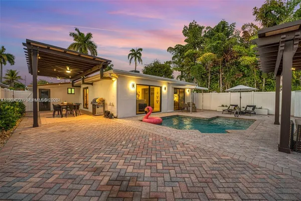 a view of a house with backyard and sitting area