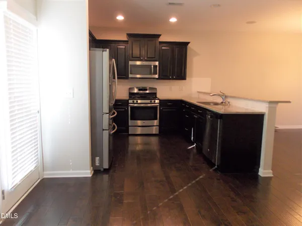 a kitchen with stainless steel appliances granite countertop a stove a sink and a refrigerator