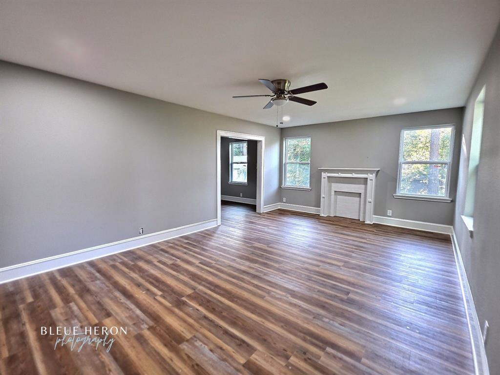 5497 Jefferson Paige Road Shreveport, LA 71119 - Photo 2 of 11 a view of empty room with wooden floor and fireplace