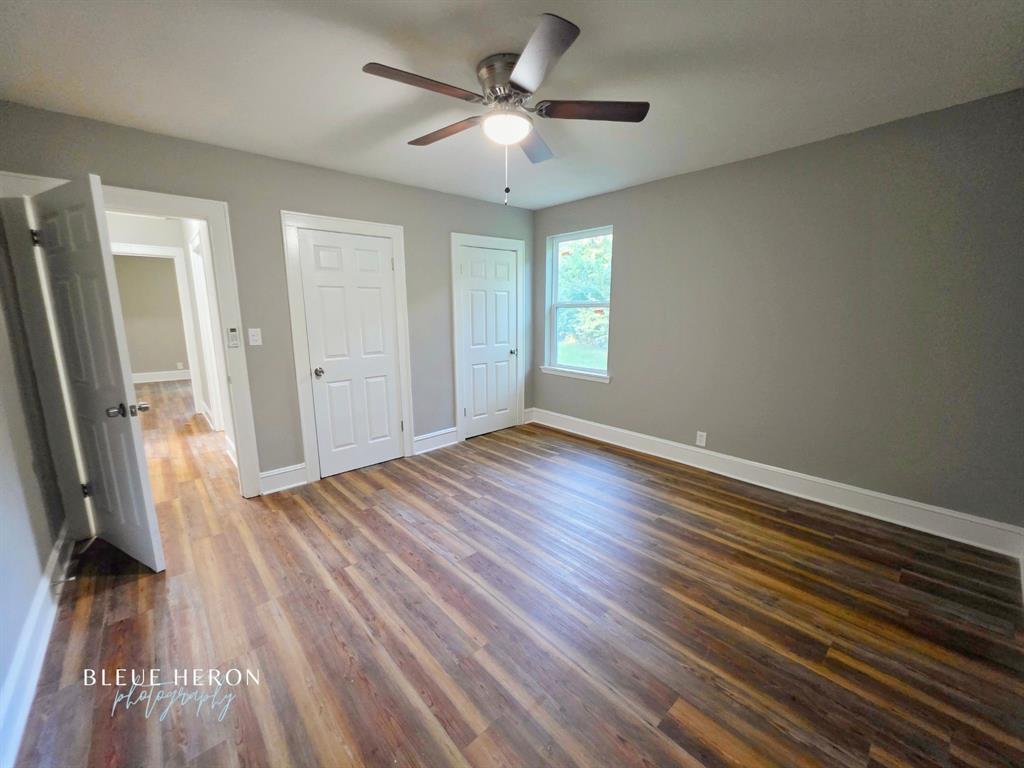 5497 Jefferson Paige Road Shreveport, LA 71119 - Photo 8 of 11 an empty room with wooden floor and a ceiling fan