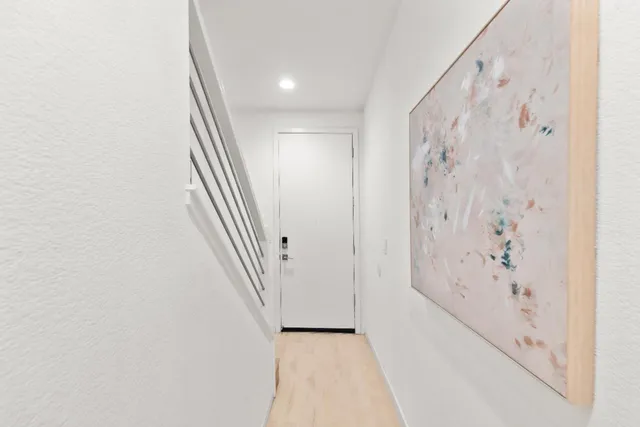 a view of a hallway with wooden floor and entryway