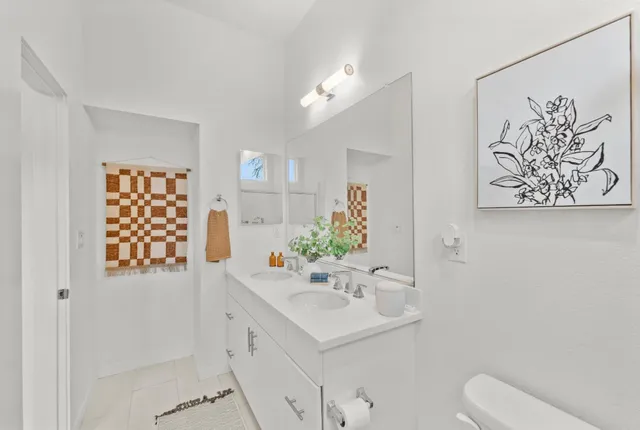 a bathroom with a sink a toilet and mirror