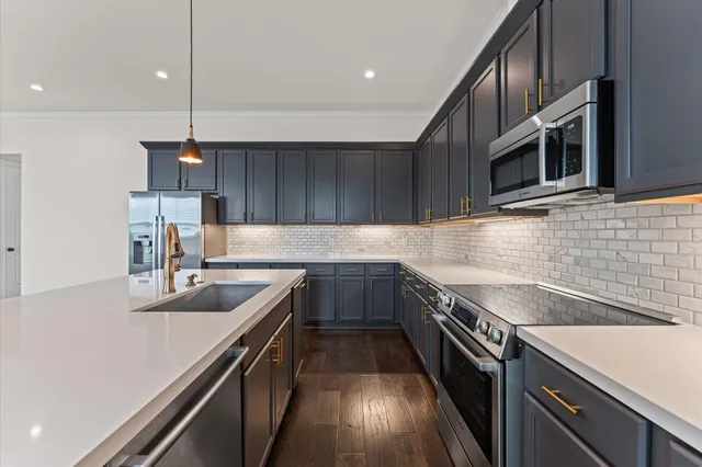 a kitchen with stainless steel appliances granite countertop a sink a stove and a microwave