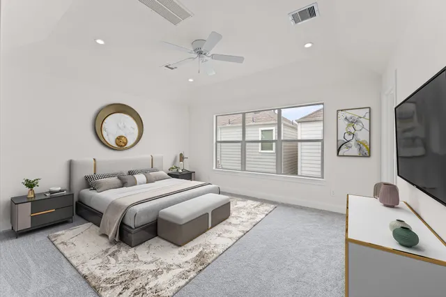 a bedroom with a bed and a flat tv screen on dresser