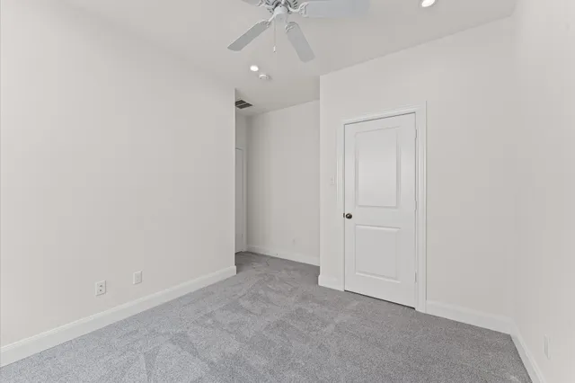 an empty room with a ceiling fan and a window