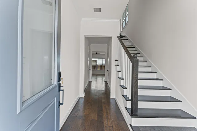 a view of a hallway with wooden floor and entryway