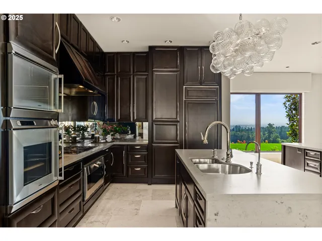 a kitchen with kitchen island granite countertop a sink counter top space cabinets and stainless steel appliances