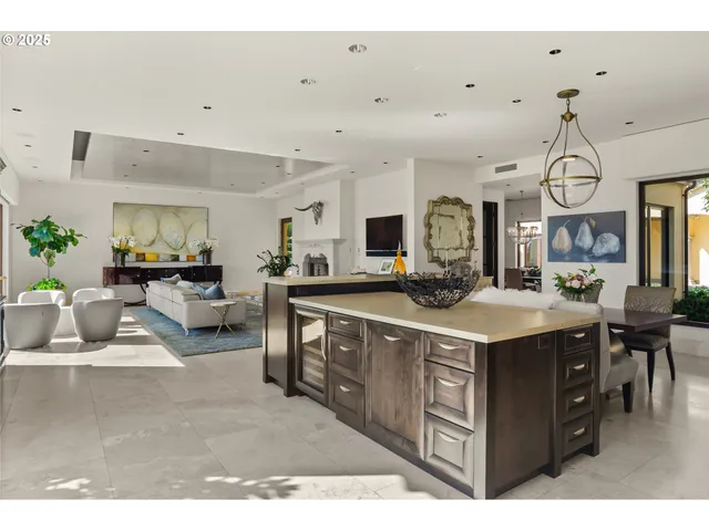 a kitchen with kitchen island granite countertop a sink a counter top space and living room view