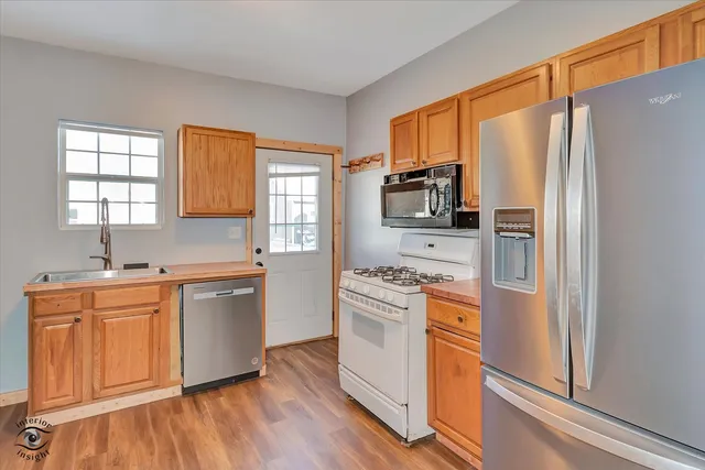a kitchen with stainless steel appliances a refrigerator sink and microwave