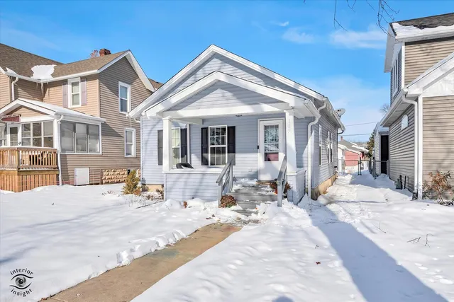 a view of a house with snow on the side of road