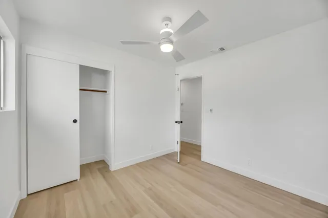 a view of a patio with a table and chairs under an umbrella with a small yard