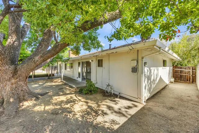 a front view of a house with a garden and tree