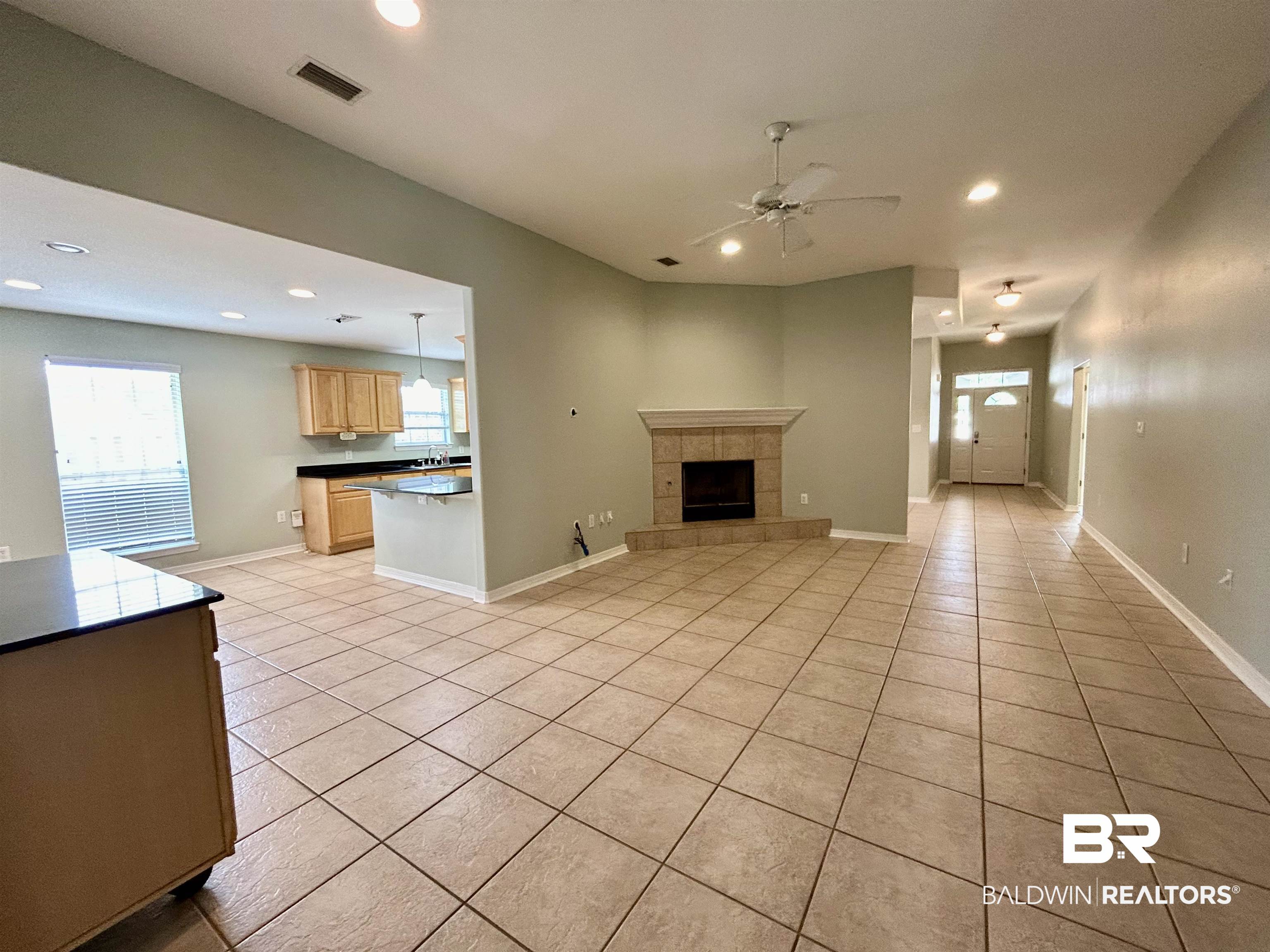 7198 Raintree Lane Gulf Shores, AL 36542 - Photo 6 of 33 Expansive living area featuring tile flooring, a corner fireplace with a tile surround and hearth, and recessed lighting