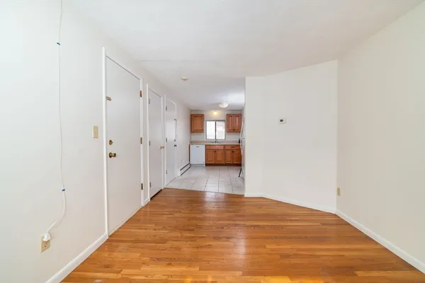 a view of a big room with wooden floor and windows