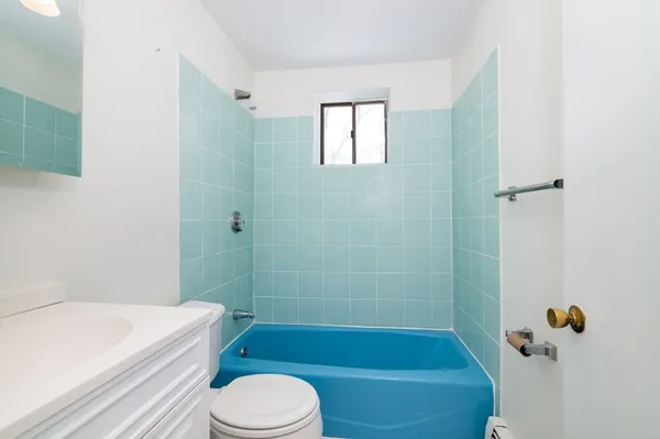 a bathroom with a toilet bathtub window and shower
