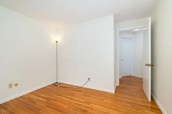 a view of an empty room with closet and mirror