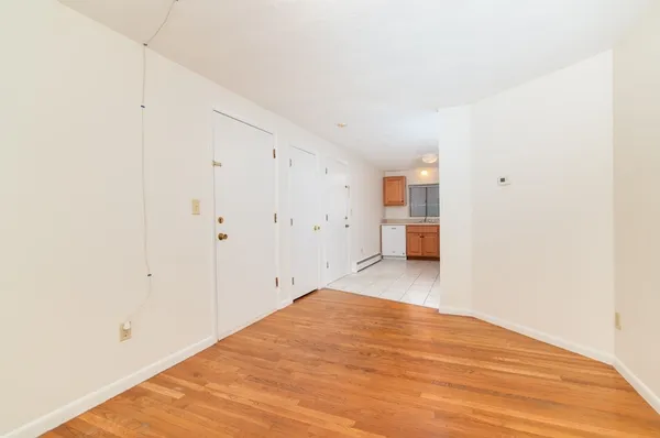 a view of empty room with wooden floor