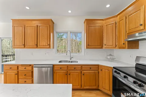 a kitchen with stainless steel appliances granite countertop a sink stove and cabinets