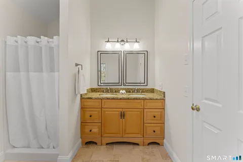 a bathroom with a granite countertop sink a vanity and a mirror