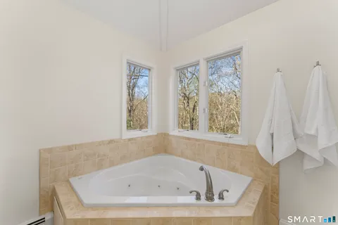 a white bath tub sitting in a bathroom next to a window
