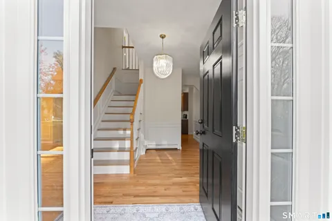 a view of entryway and hall with wooden floor