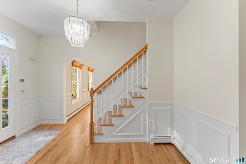 a view of entryway and hall with wooden floor