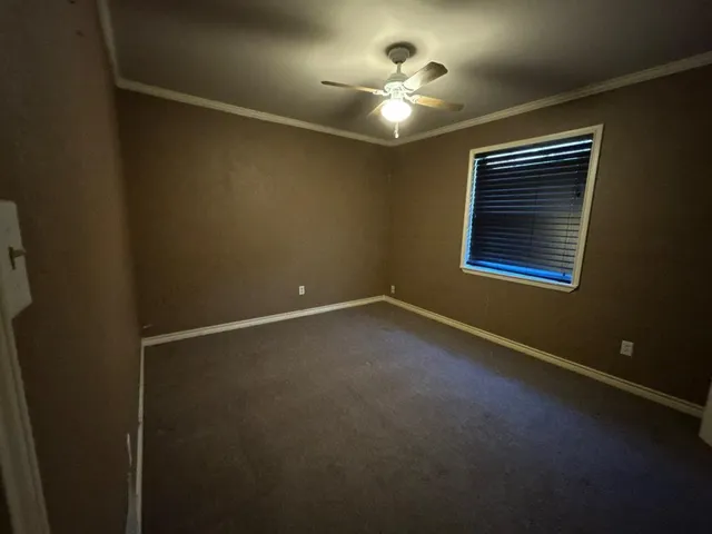 en empty room with windows and chandelier fan