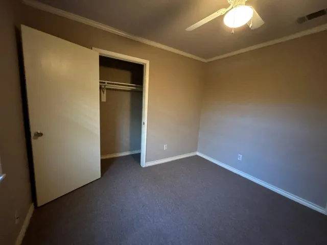 a view of an empty room with closet and a fireplace
