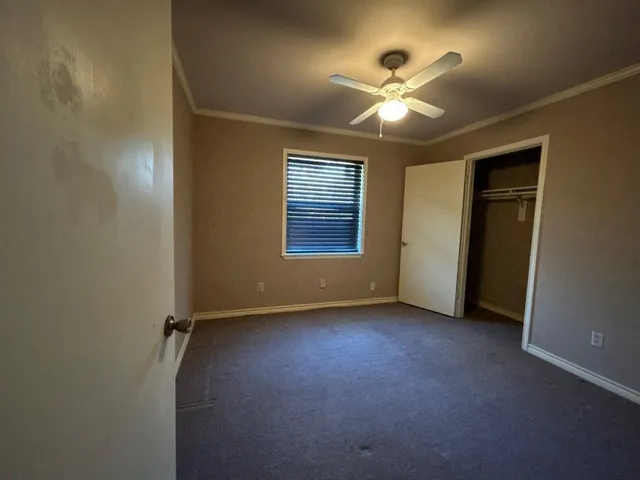 an empty room with fan and windows