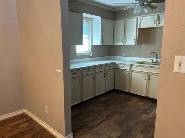 a view of cabinets a sink and a window in a room