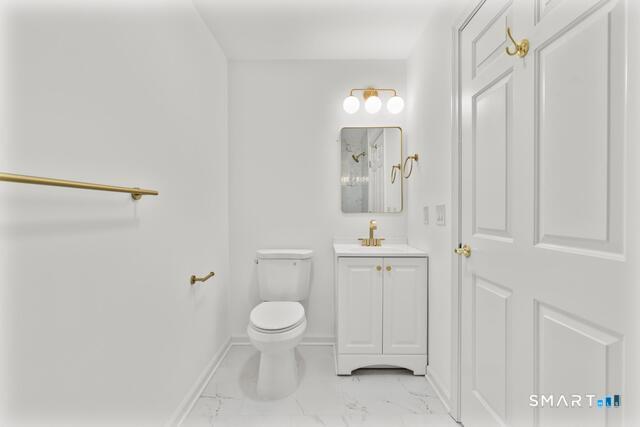 468 Main Street, Unit 111 East Lyme, CT 06357 - Photo 21 of 25 a bathroom with a toilet a sink and mirror