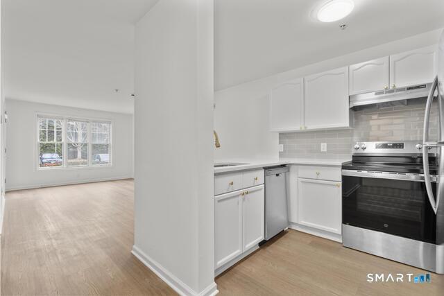 468 Main Street, Unit 111 East Lyme, CT 06357 - Photo 22 of 25 a kitchen with stainless steel appliances granite countertop a stove and a sink