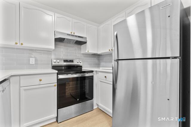 468 Main Street, Unit 111 East Lyme, CT 06357 - Photo 24 of 25 a white refrigerator freezer sitting in a kitchen