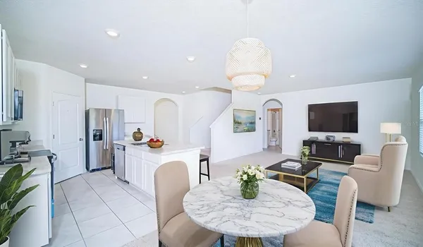 a living room with furniture a flat screen tv and kitchen view
