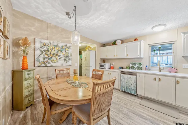 a kitchen with stainless steel appliances granite countertop a kitchen island a stove a table and chairs